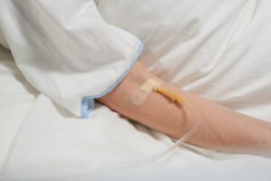 Woman's hand with IV drip for chemotherapy or immunotherapy