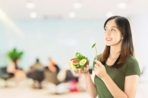 Woman thinking about diet with bowl of salad in hand